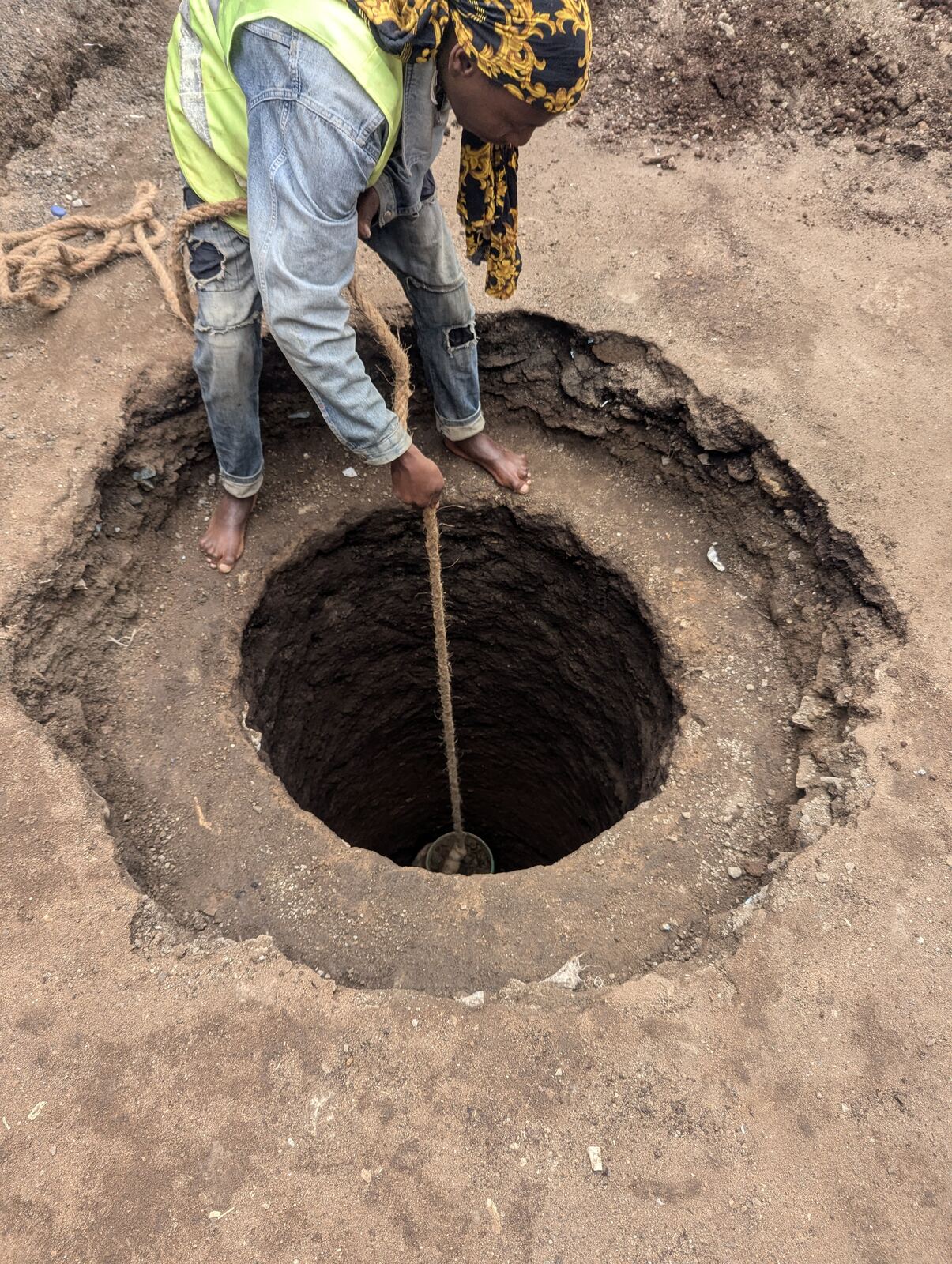 BRF team measuring the depth of the hand-dug well during construction