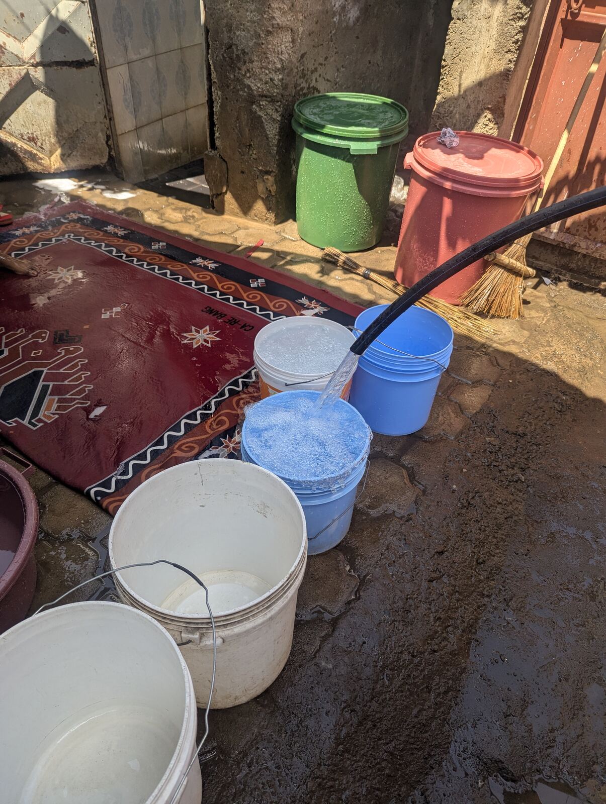 Testing water flow from the newly dug well into storage buckets