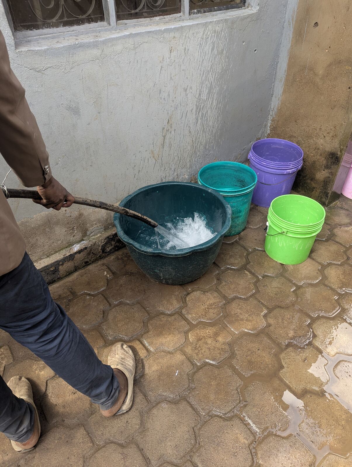 Water flowing from the completed well into buckets, the first successful test